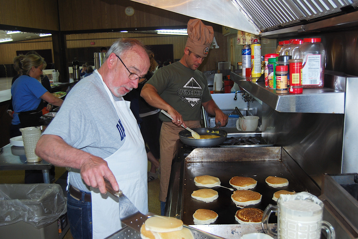 Man cooking up pancakes on the grill